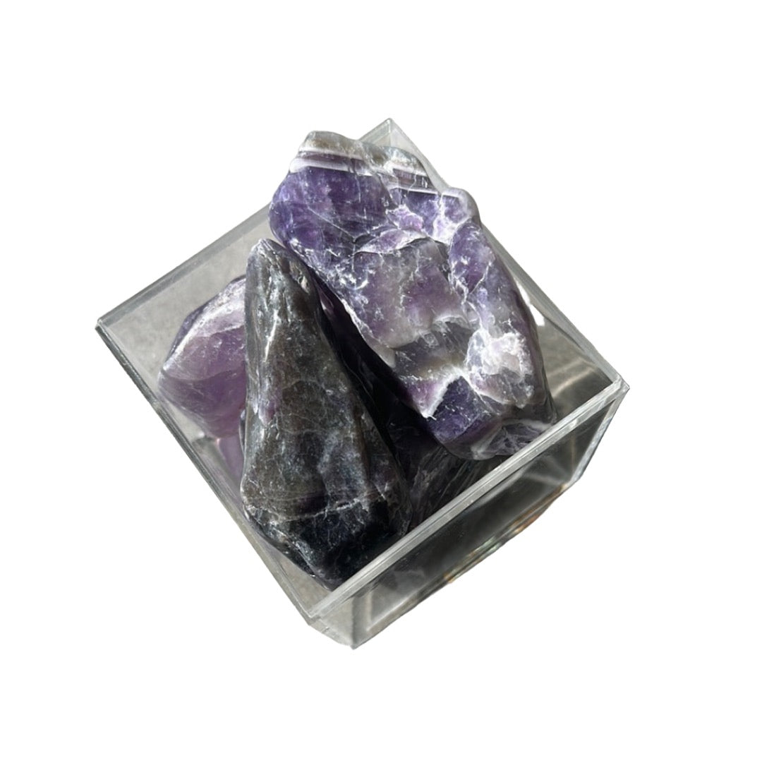 Chevron amethyst natural points in a glass container showcasing unique purple and white chevron patterns, ideal for calming energy.