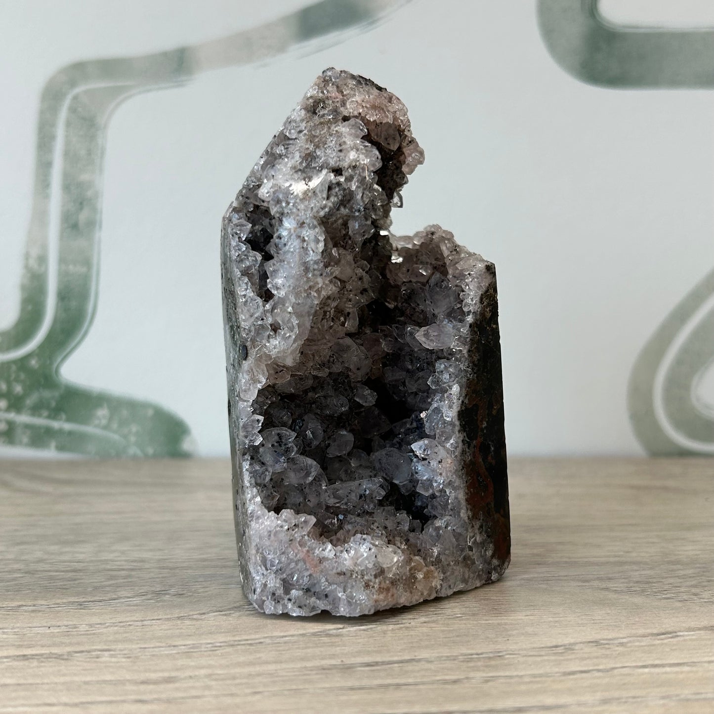 Raw agate crystal tower on wooden surface for aura cleansing and healing.