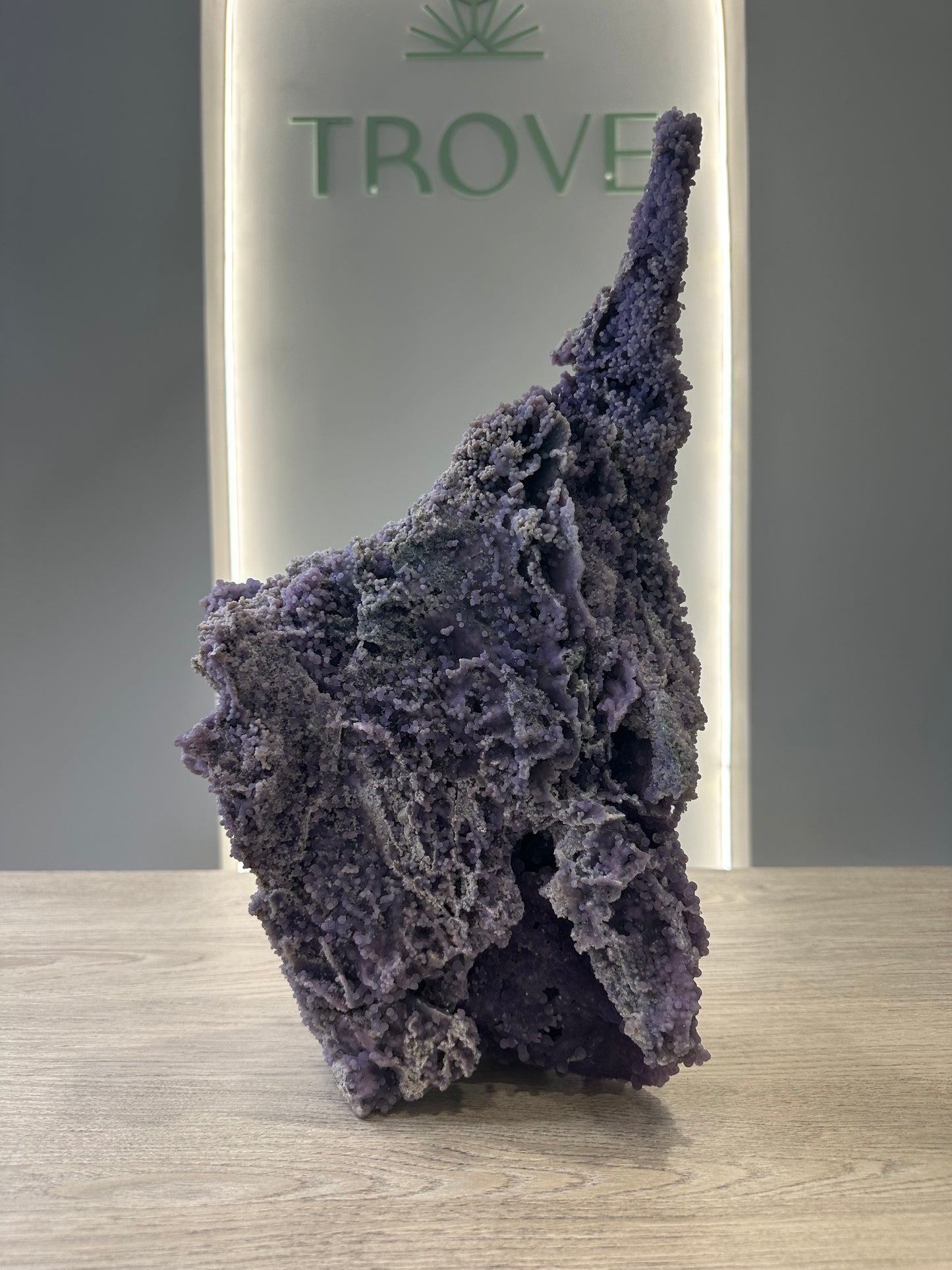 Grape Agate Free Form crystal with healing properties for meditation, enhancing inner strength and stress relief, displayed on a table.