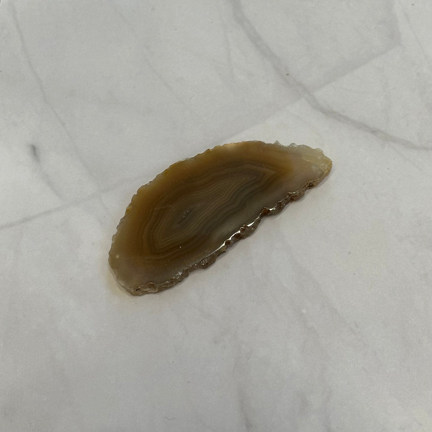 Natural agate slice on white background, ideal for rebalancing body, mind, and spirit; enhances aura and transforms negativity.
