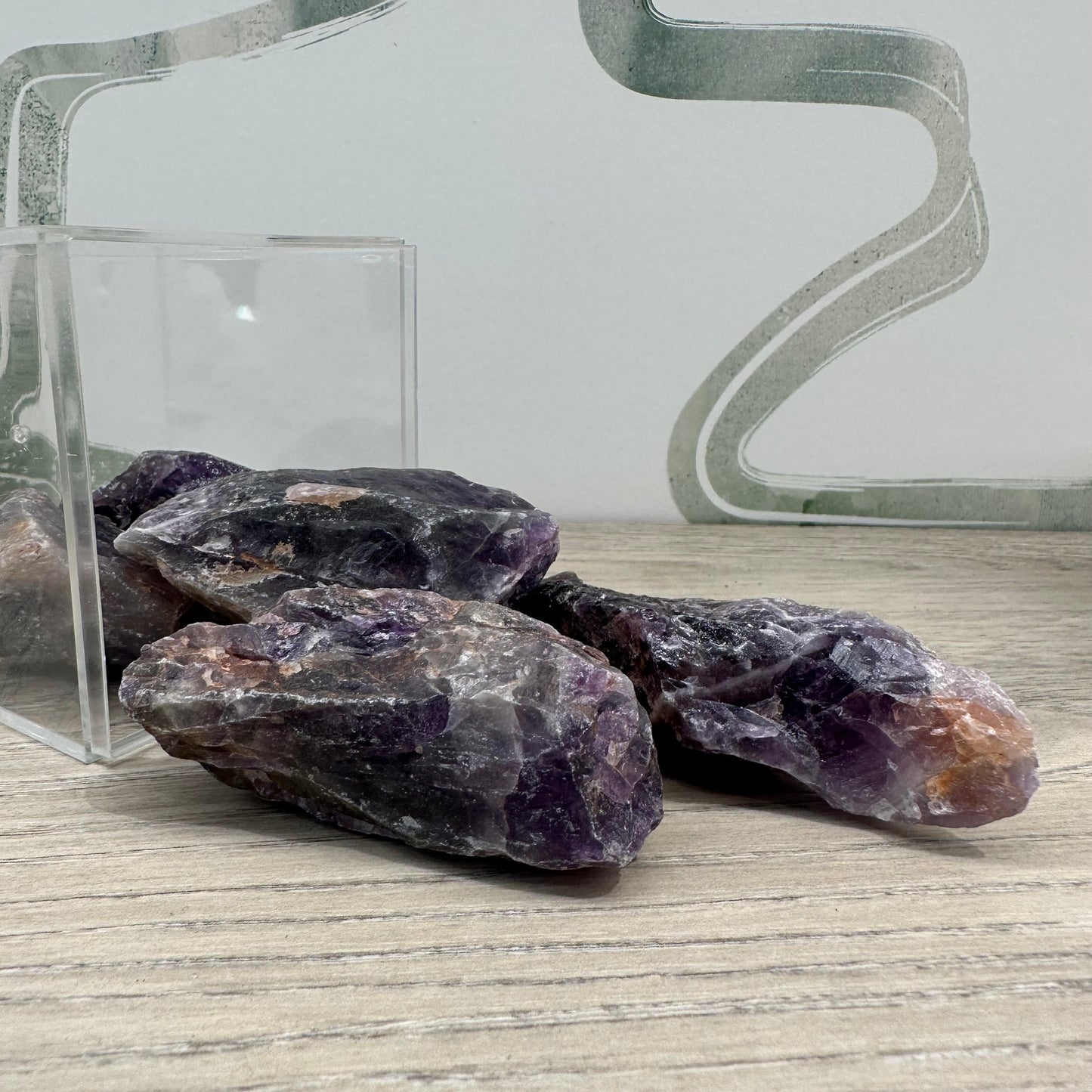 Raw amethyst healing crystals 2-4 inches, promote stress relief, mood stabilization, and clarity, displayed on a wooden surface.