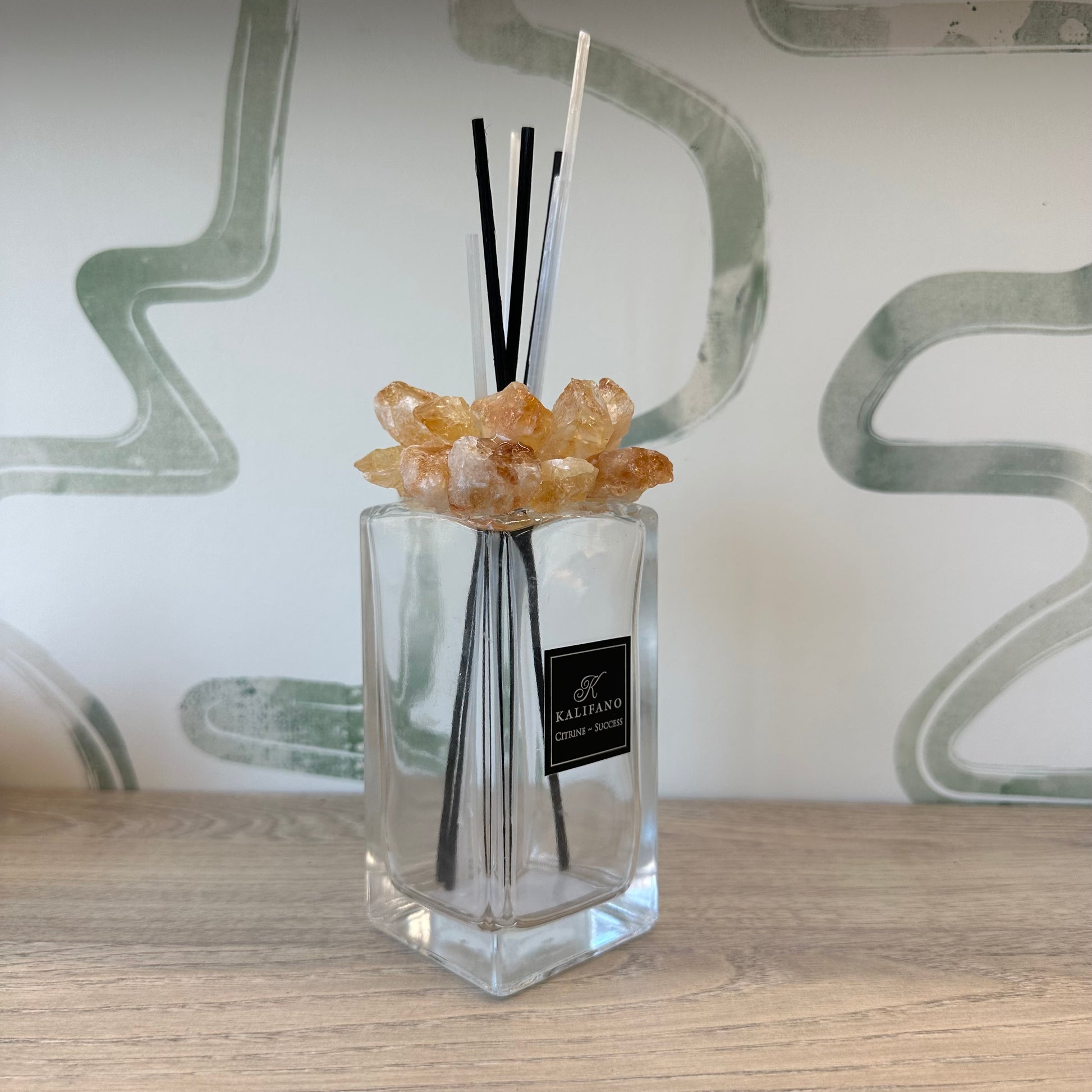 Citrine diffuser with aroma sticks and crystal accents on a wooden surface, enhancing home decor and ambiance.