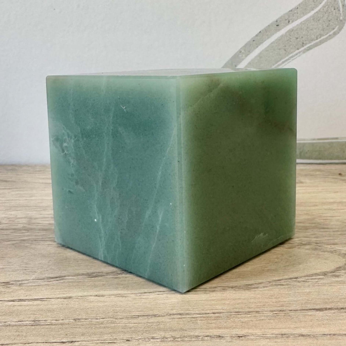 Green Aventurine Cube 426g on wooden surface, promoting healing and balance of energies.