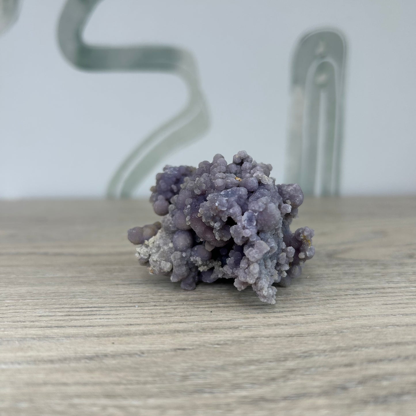 Grape Agate Free Form mineral on wooden surface, 89g, known for stimulating inner strength, purification, and stress relief.