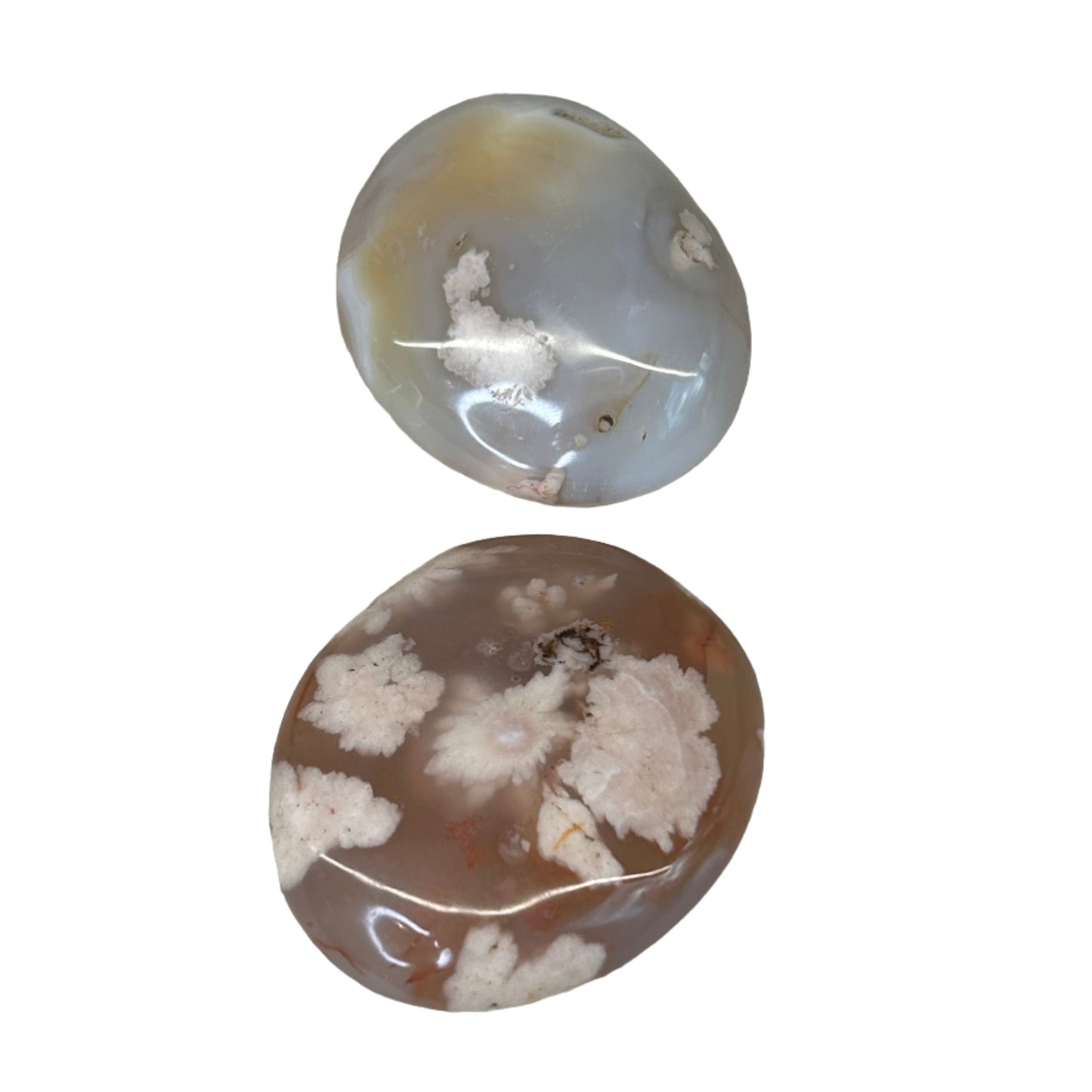 Two translucent Flower Agate palm stones with light pink hues and delicate inclusions, known for healing properties.