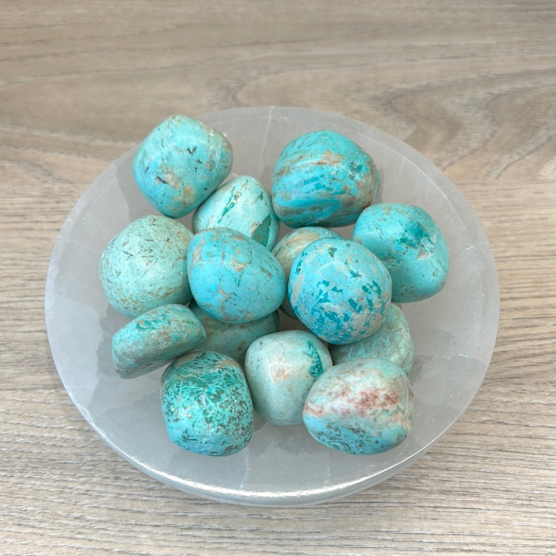Turquoise tumbled stones known for purification and emotional balance, enhancing energy and promoting a sense of peace.