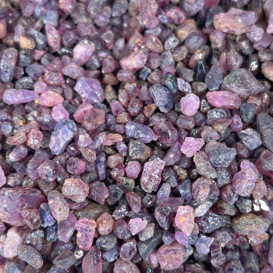Close-up of ruby chips showcasing vibrant pink and purple hues, ideal for promoting passion and motivation.