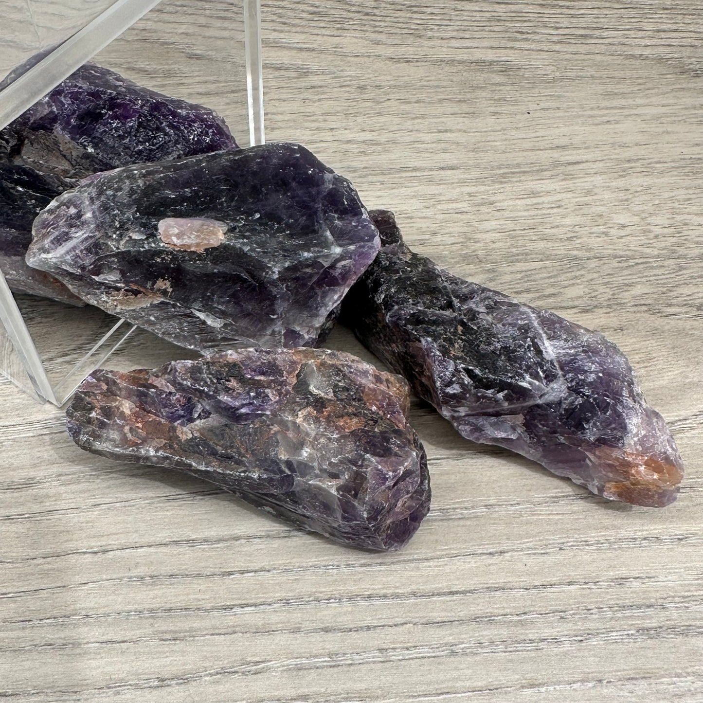 Amethyst rough healing crystals for stress relief and spiritual enhancement on wooden surface.