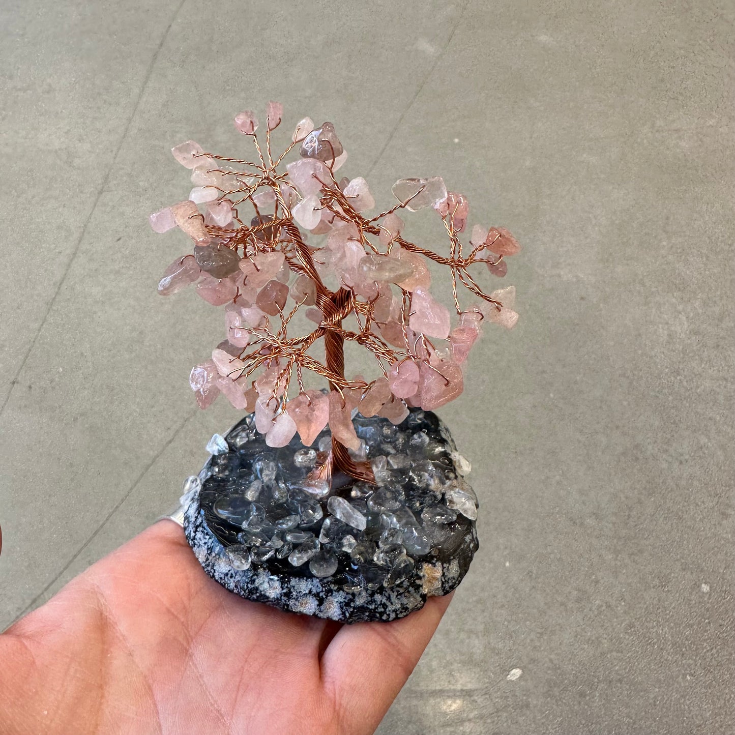 Rose Quartz Tree of Life with Agate Base held in hand, featuring natural gemstones and intricate handcrafted design.