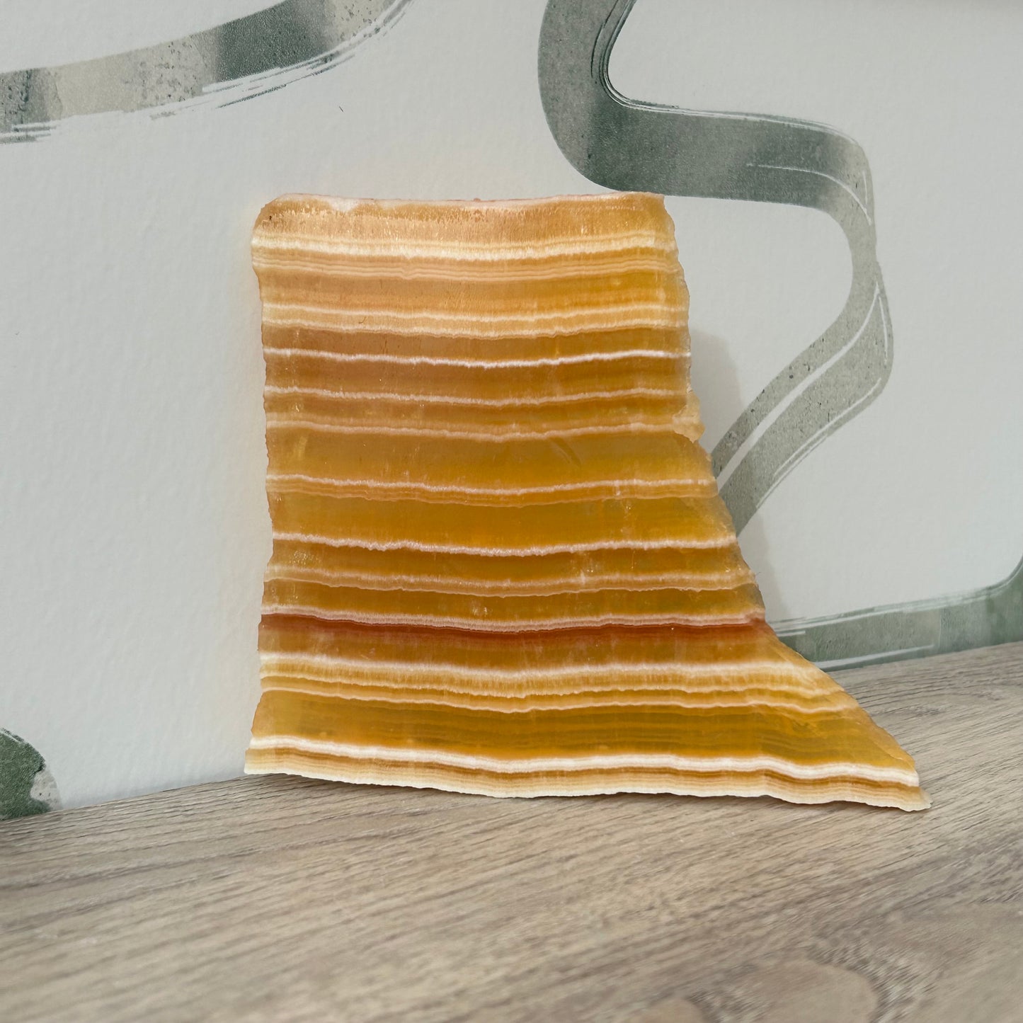 Beautiful orange calcite slab with layered stripes, perfect for enhancing wellbeing and clearing negative energy.