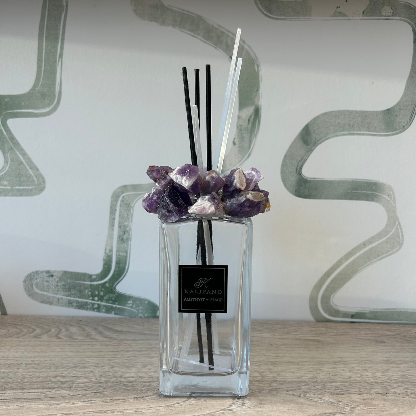 Amethyst diffuser with healing crystals and reed sticks in a glass bottle, enhancing home decor and wellness ambiance.