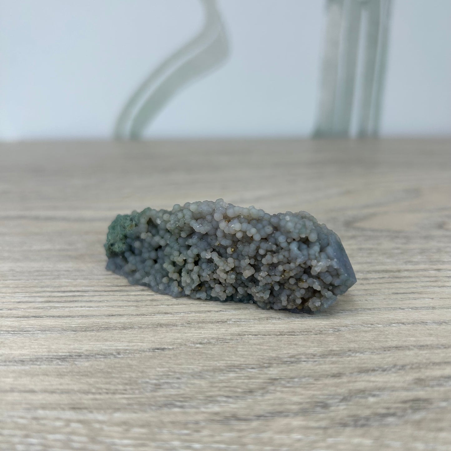 Grape Agate stone with polished side on wood surface, ideal for meditation, inner strength, and stress relief, weighing approximately 58g.