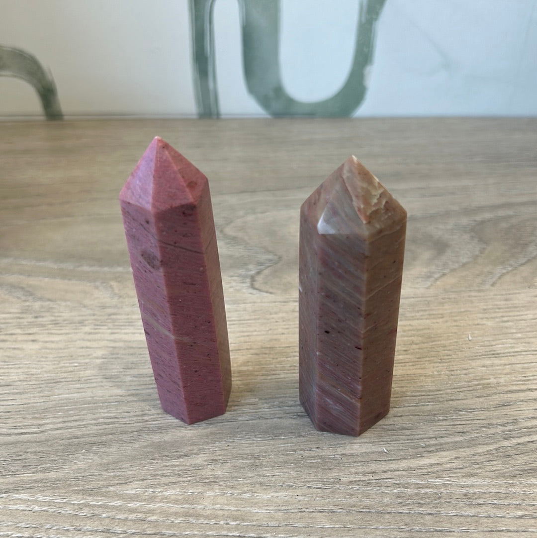 Rhodonite tower crystals showcasing pink and red hues, promoting emotional balance and healing energy.