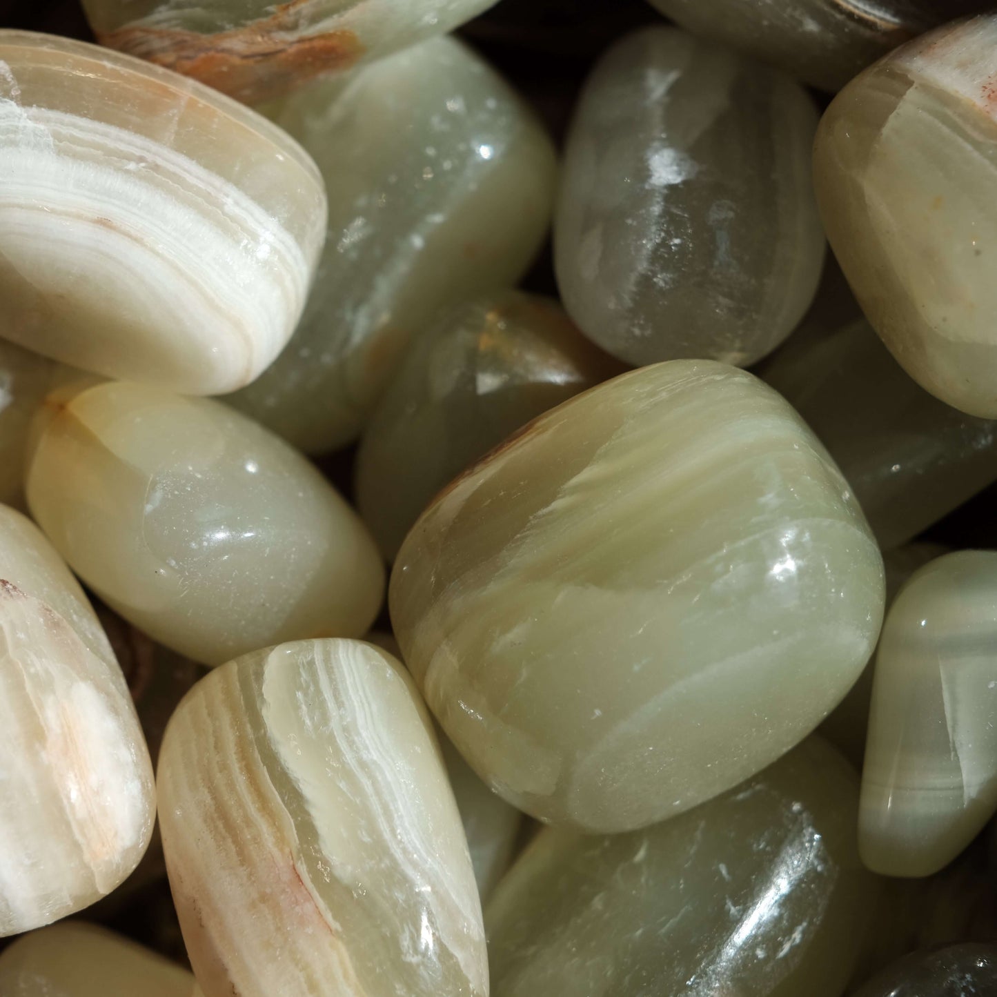 Green Onyx tumbled stones showcasing natural patterns and hues, perfect for enhancing strength, willpower, and emotional balance.