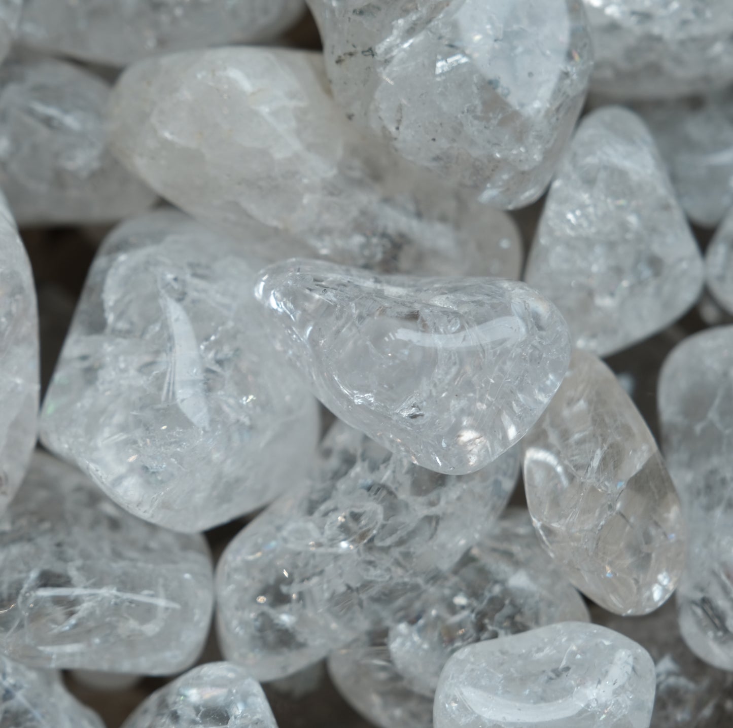Cracked clear quartz tumbled stones, known for energy amplification and balance, perfect for enhancing focus and spiritual well-being.