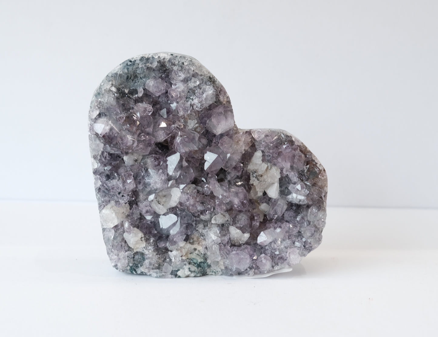 Amethyst heart healing crystal on stand, used for stress relief, mood stabilization, and enhancing spirituality.