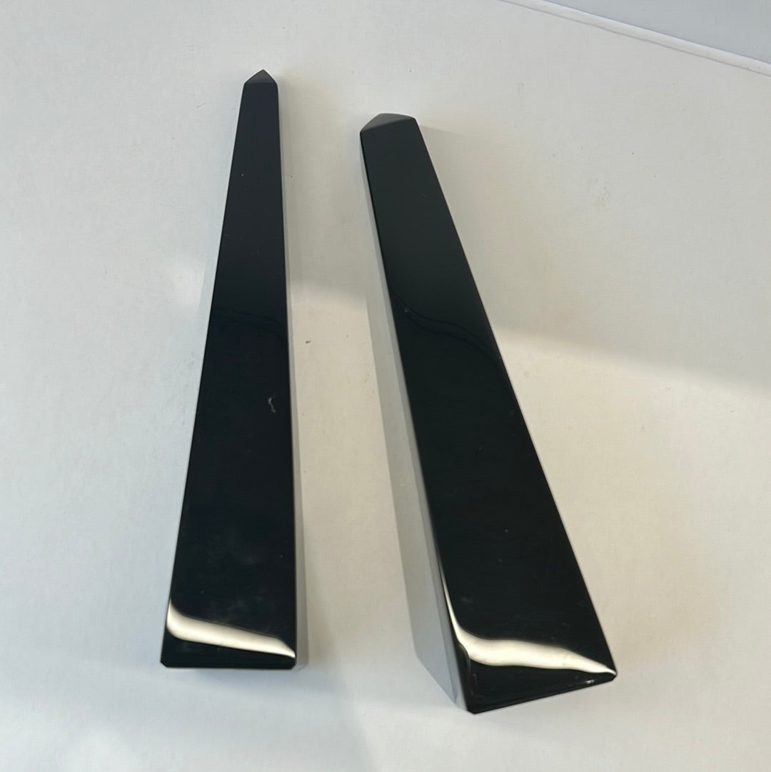 Black obsidian obelisks featuring polished surfaces, known for protection and clarity in personal growth and self-discovery.