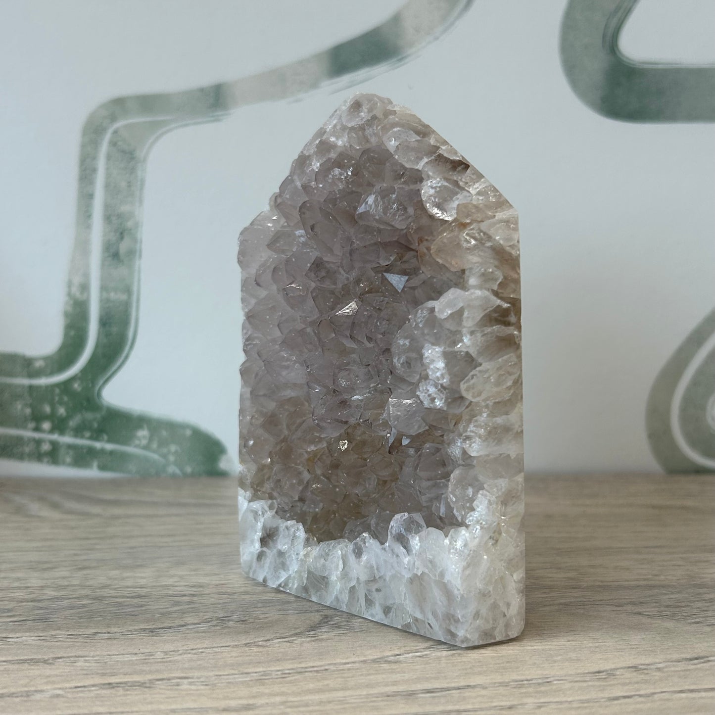 Agate Tower crystal stone, 4.4 inches high, for healing and aura cleansing on a wooden surface with abstract background.