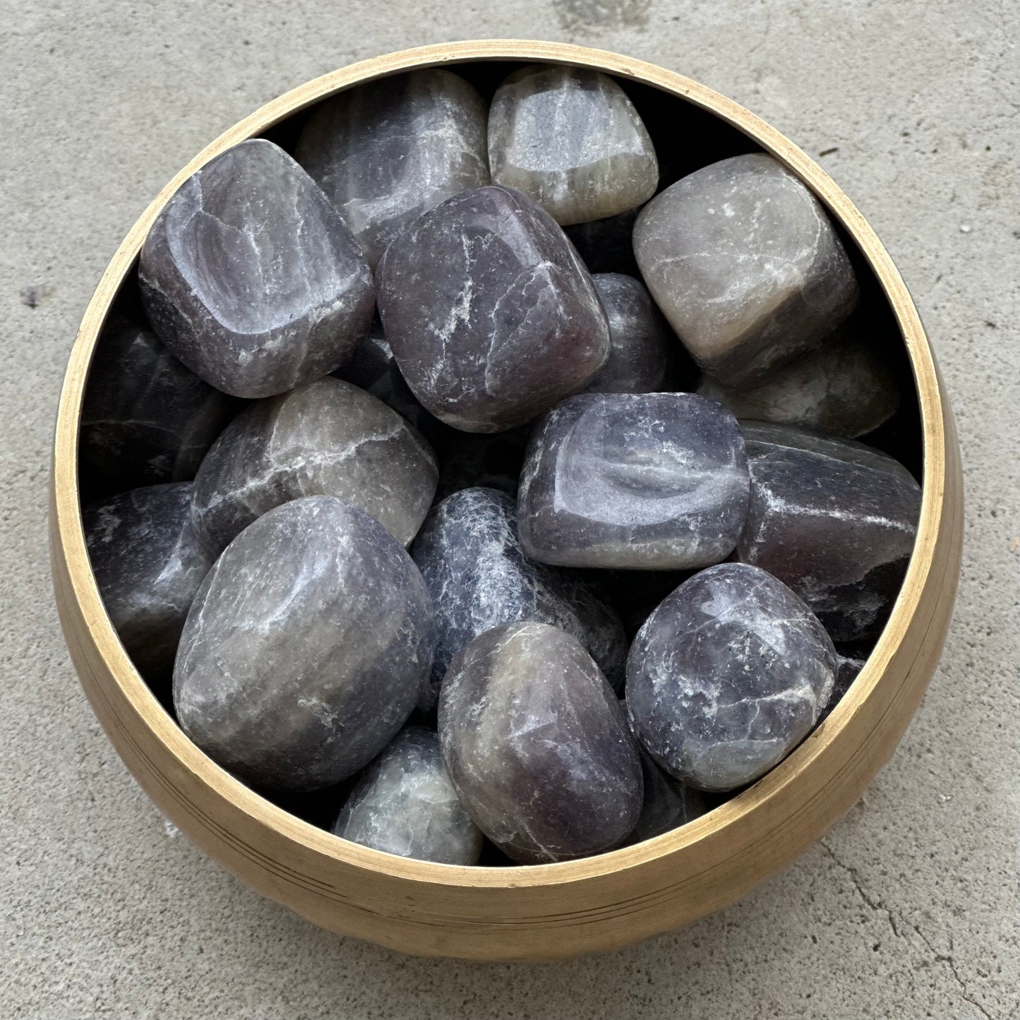 Bowl of Iolite tumbled stones for enhancing intuition and fostering self-expression.