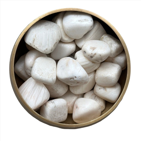 Scolecite tumbled stones in a wooden bowl, ideal for meditation and relaxation, known as the stone of inner peace.