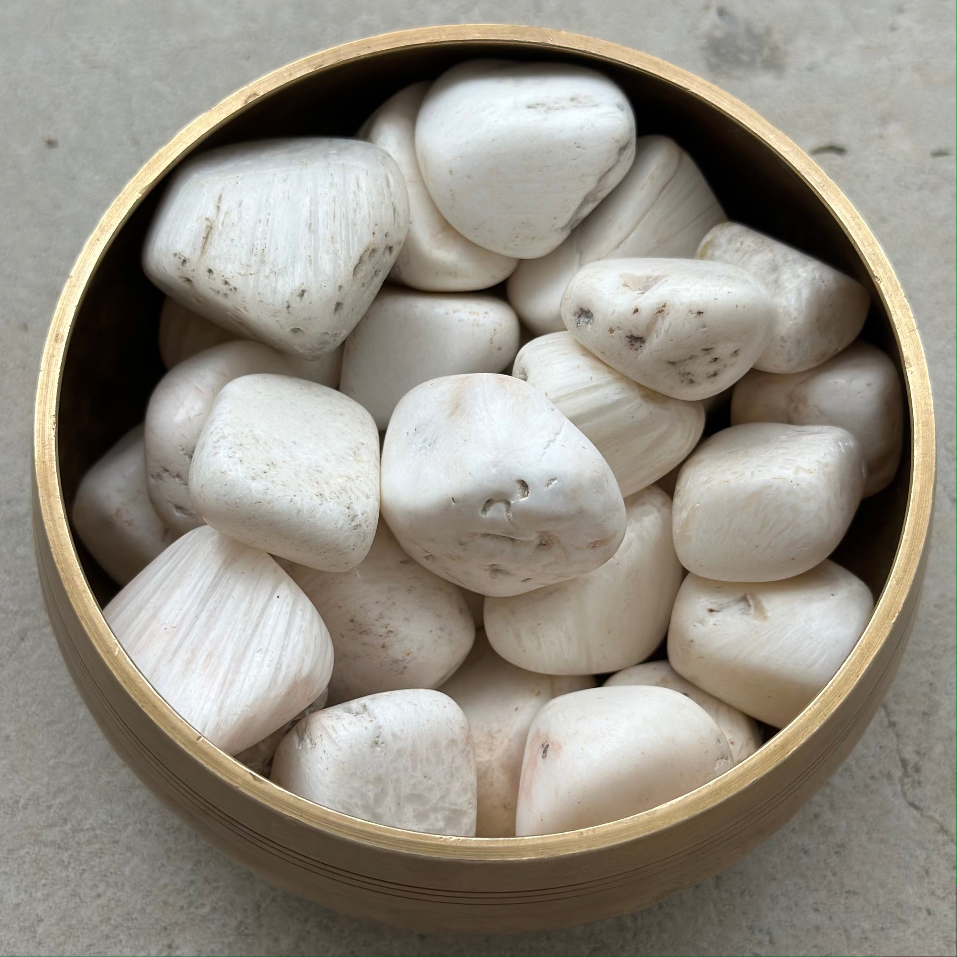 Bowl of white Scolecite tumbled stones for relaxation and meditation.