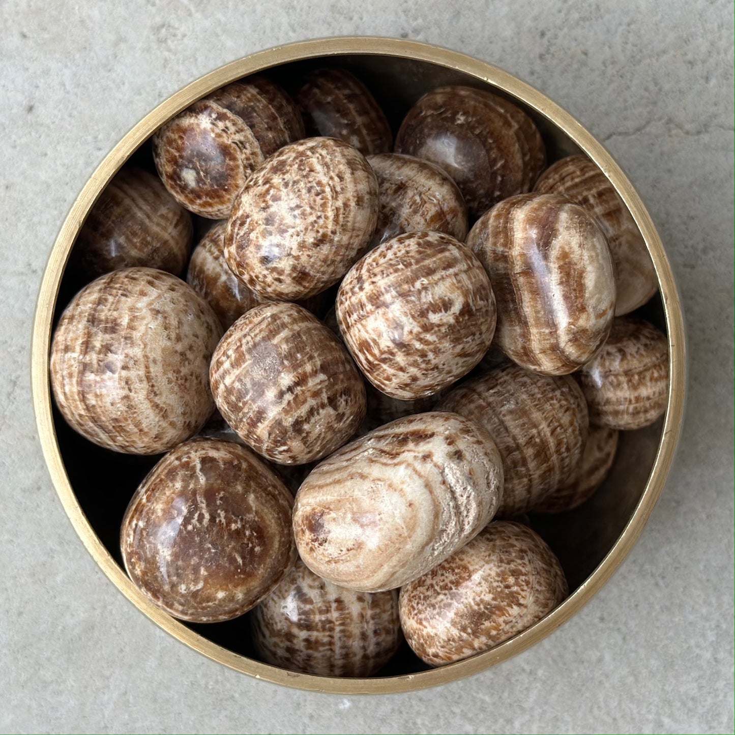 Bowl of brown aragonite tumbled stones for grounding and centering energies.