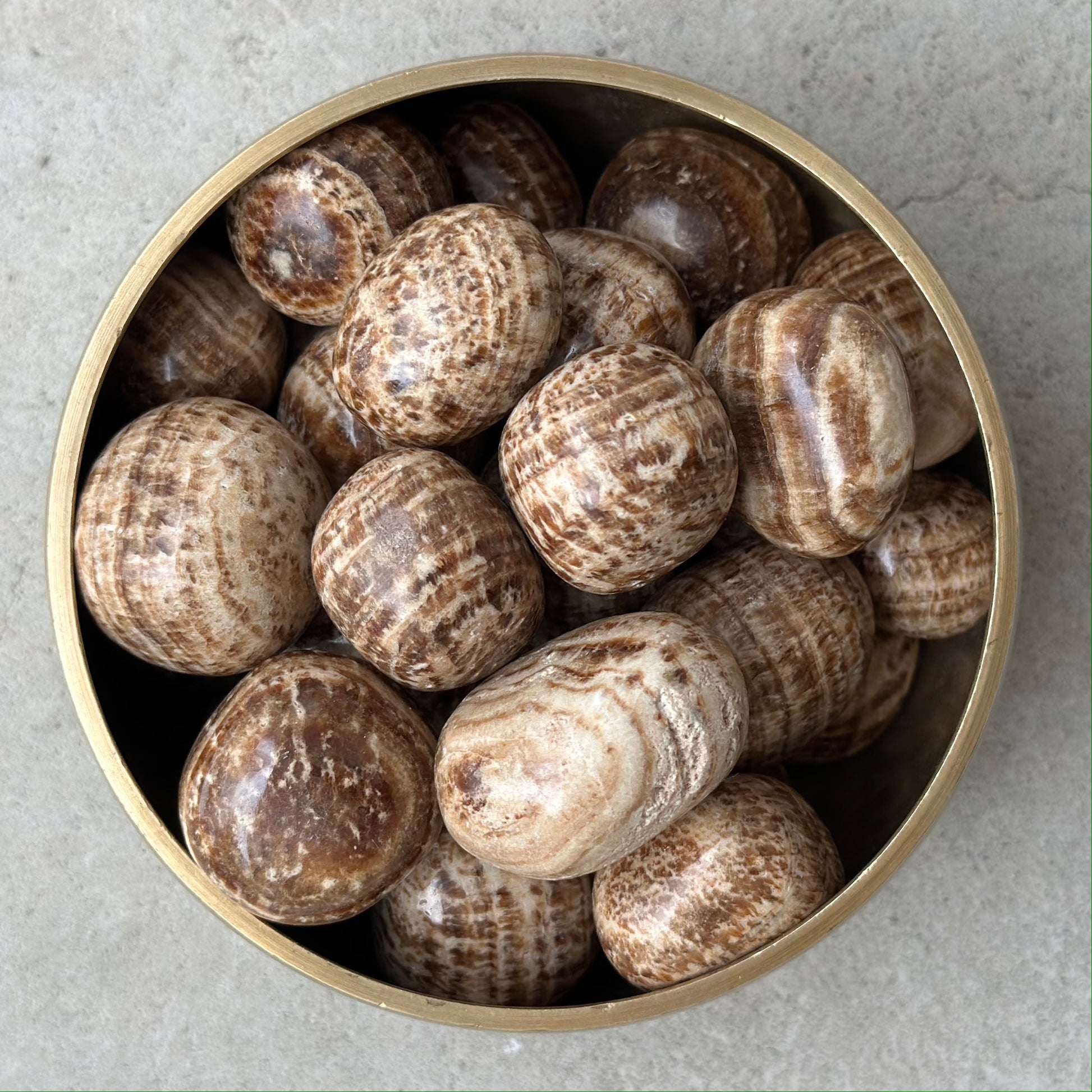Bowl of brown aragonite tumbled stones for grounding and centering energies.