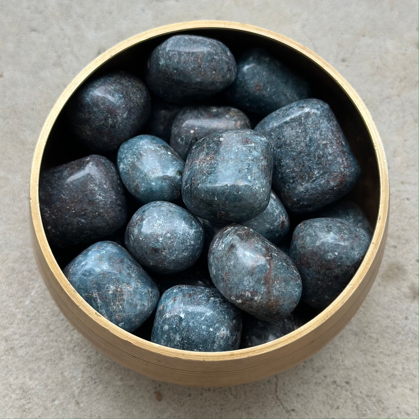 Bowl of polished Kyanite tumbled stones for healing and chakra balancing.