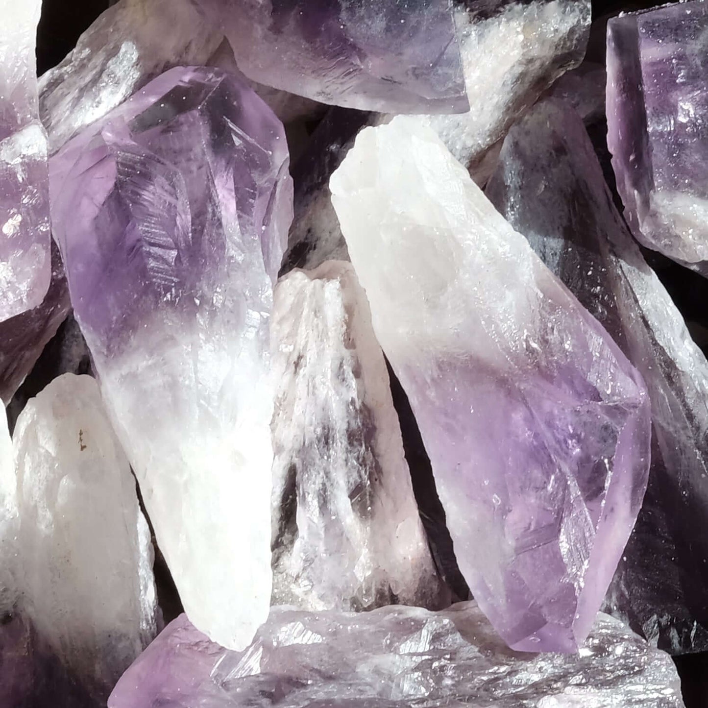 Various raw amethyst crystals showcasing natural purple hues and rough textures, known for stress relief and spiritual benefits.
