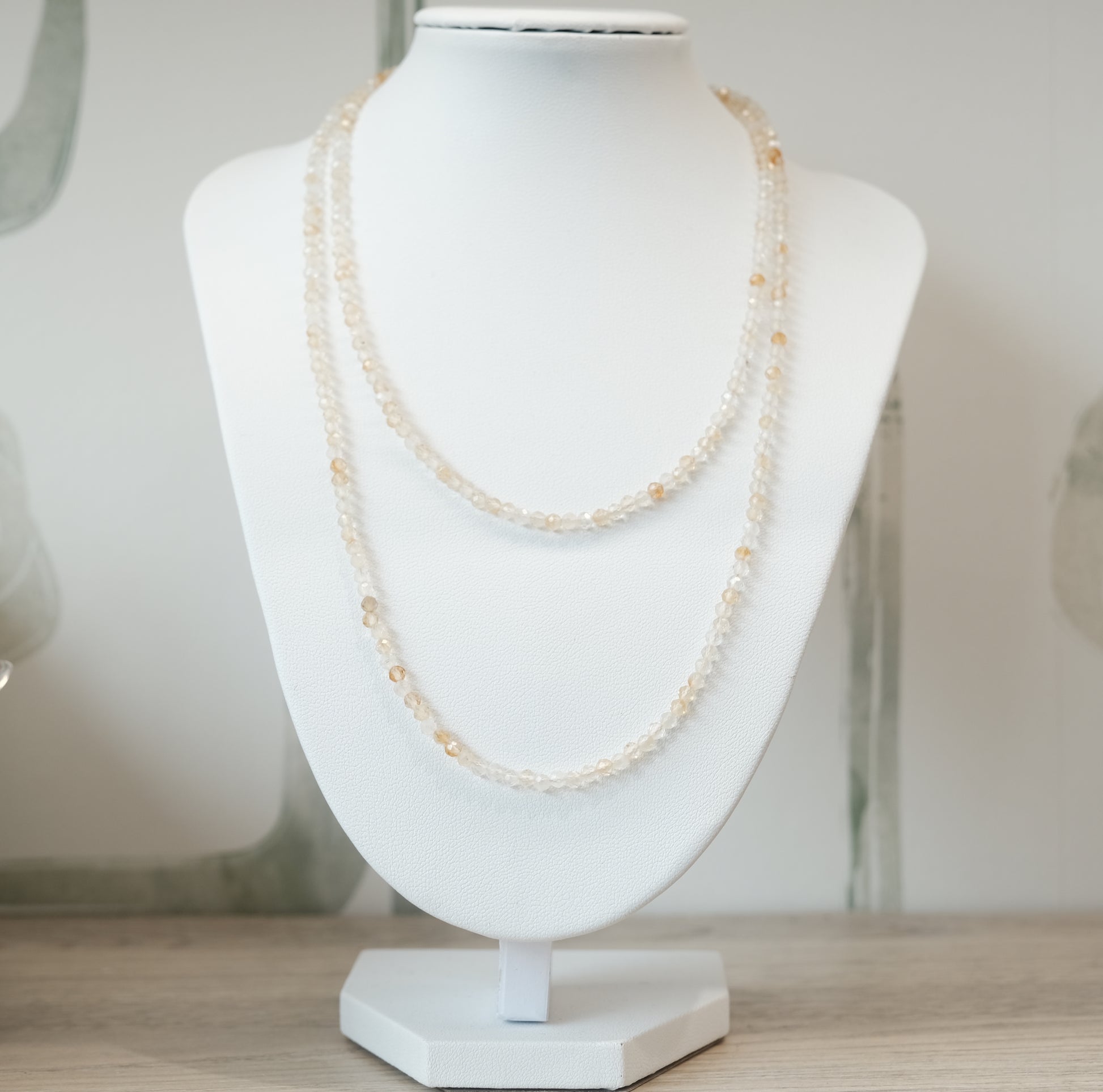 Citrine faceted 31" necklace multi-wrap bracelet displayed on stand, enhances intuition and attracts wealth and success.