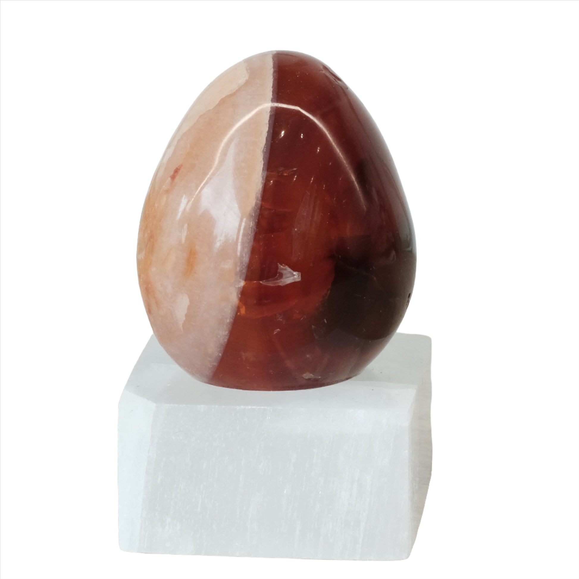 Carnelian egg on a white base, promoting vitality, creativity, and healing benefits for body and mind.