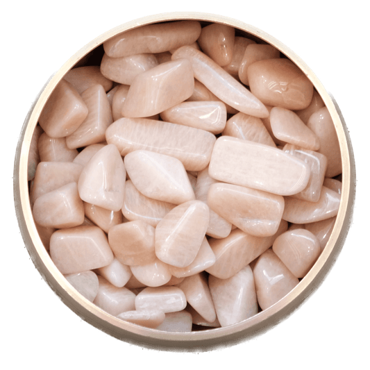 Peach Moonstone tumbled stones in a round bowl, promoting inner strength, serenity, and creativity for new beginnings.