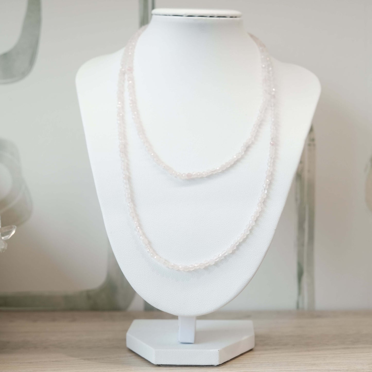 Elegant Rose Quartz Faceted Necklace and Multi Wrap Bracelet on Display Stand, Symbolizing Love and Healing.