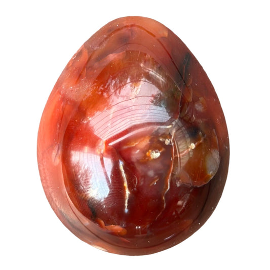 Carnelian egg for vitality, creativity, and emotional healing; promotes positive choices and boosts fertility.