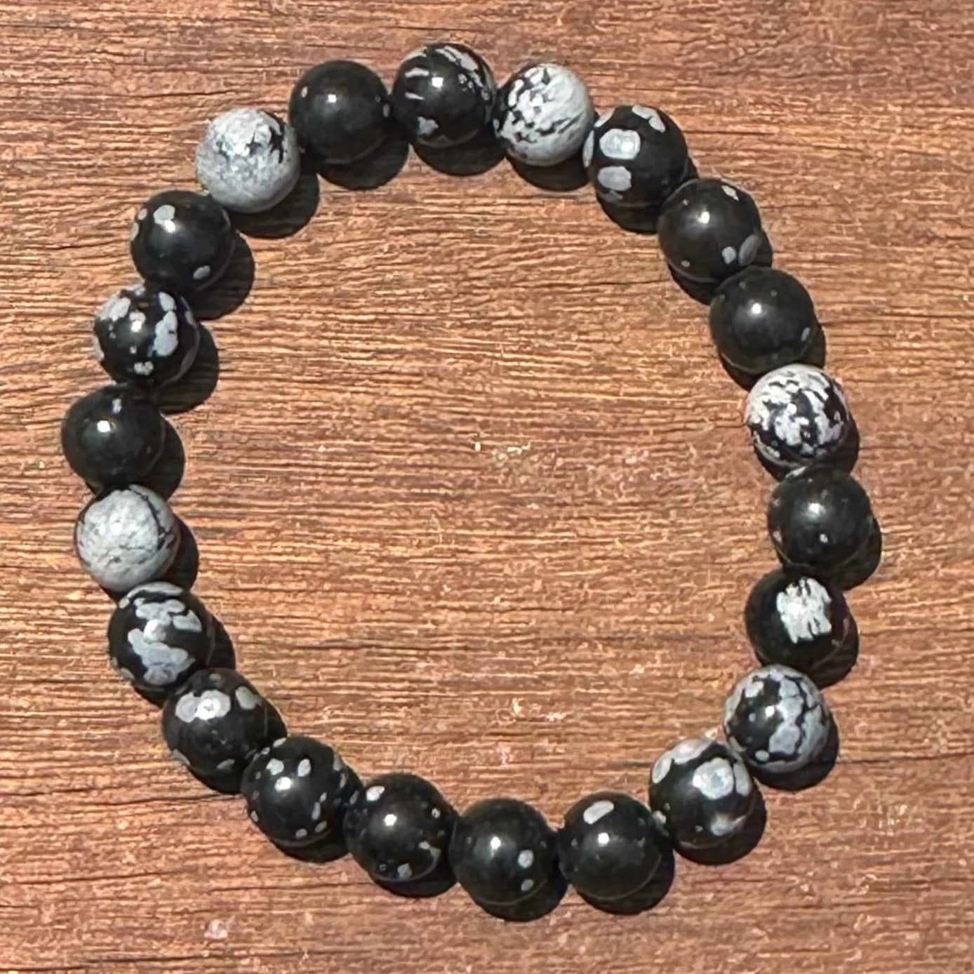 Snowflake Obsidian bracelet featuring 8mm beads, promoting safety and resilience in life's situations.