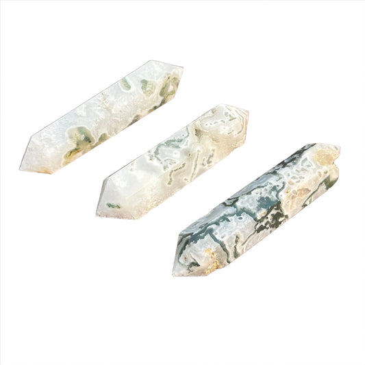 Moss agate double terminated points showcasing green moss-like inclusions on a white background, known for healing properties.