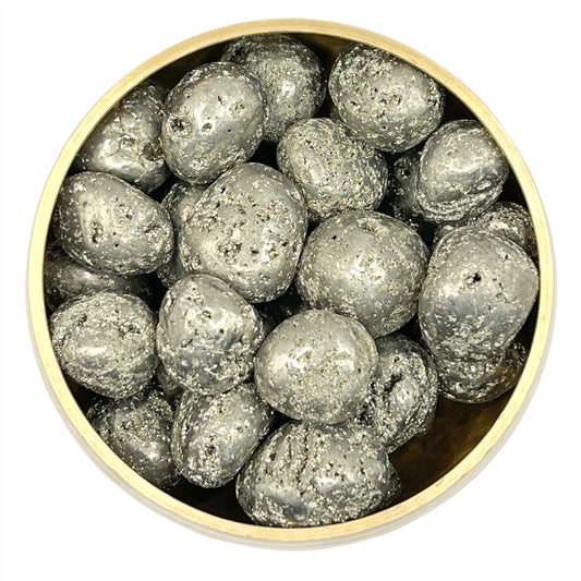 Bowl of shiny pyrite tumbled stones with healing properties for mind and body, enhancing respiratory health and metabolism.