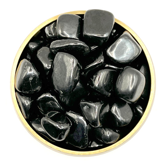 Bowl of polished shungite tumbled stones for healing and purification.