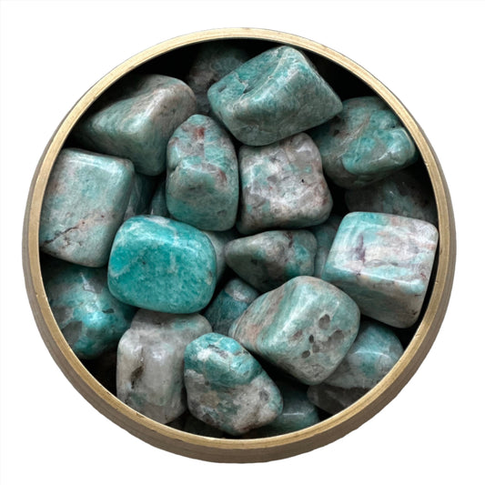 "Collection of amazonite tumbled stones in a circular container, showcasing their soothing green-blue color and polished surface."