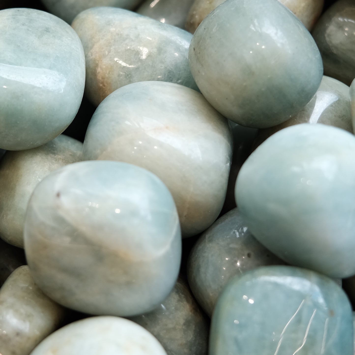 Smooth aquamarine tumble stones 20-30mm, known for calming effects and promoting courage, ideal for stress reduction and mindfulness.