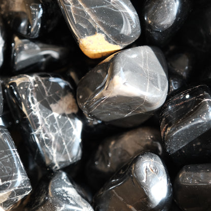 Shiny black onyx tumble stones 20-30MM for promoting vigor and self-confidence with healing properties for bone and blood disorders.