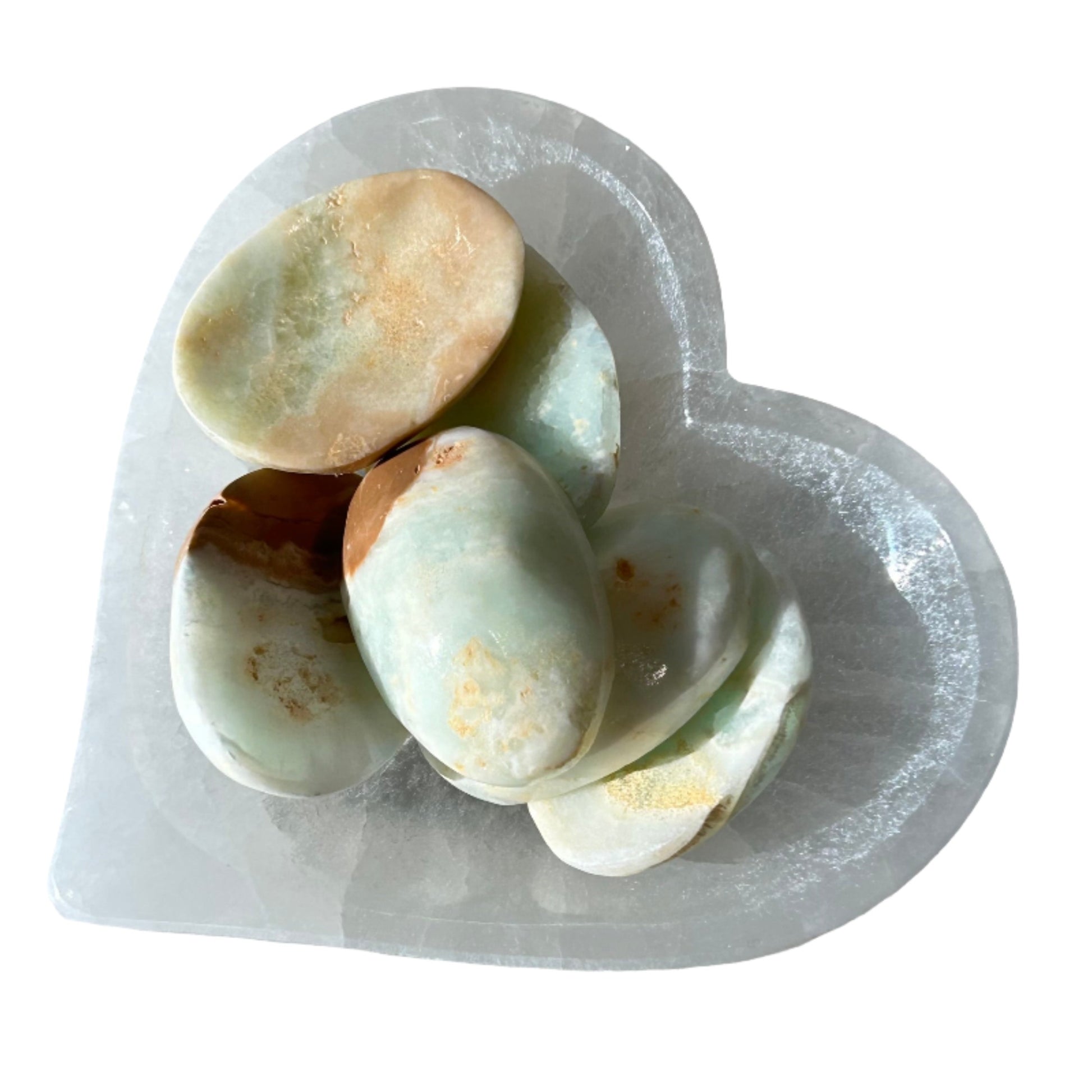 Caribbean calcite worry stones resting in a heart-shaped dish, promoting serenity and personal growth.