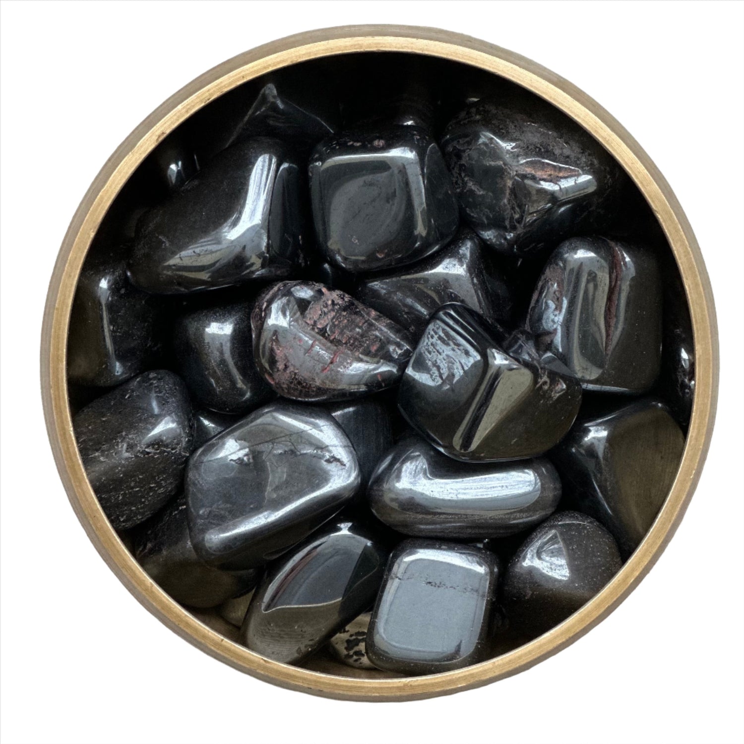 Hematite tumbled stones in a round container, known for grounding and protective properties, enhancing focus and balance.