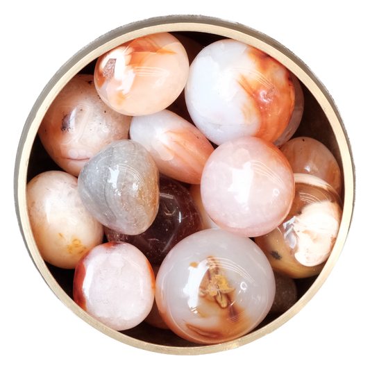 Assorted polished Carnelian stones in a round container showcasing their vibrant orange and red hues.