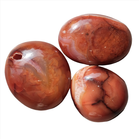 Three polished Carnelian palm stones for vitality and creativity stimulation.