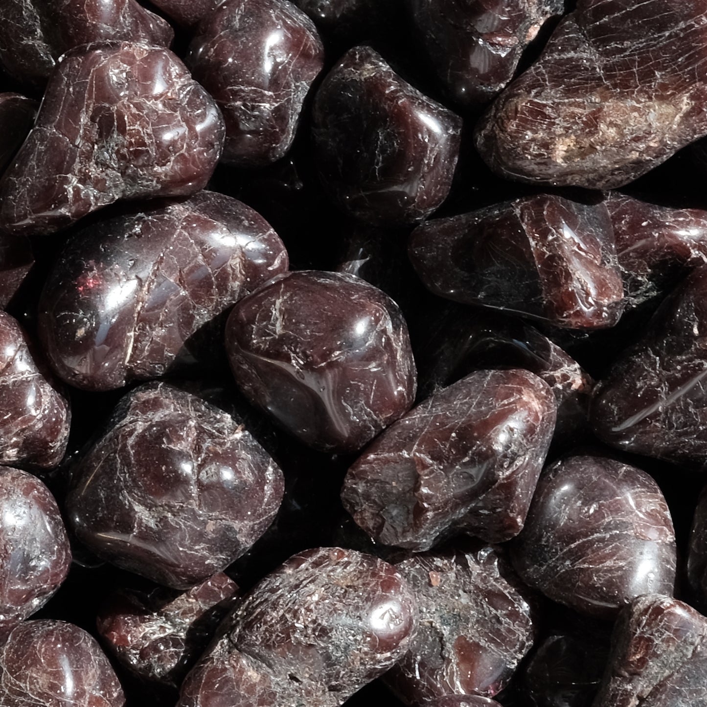 Tumbled garnet stones 10-20MM, showcasing their deep red hue and smooth texture, ideal for energy balance and revitalization.