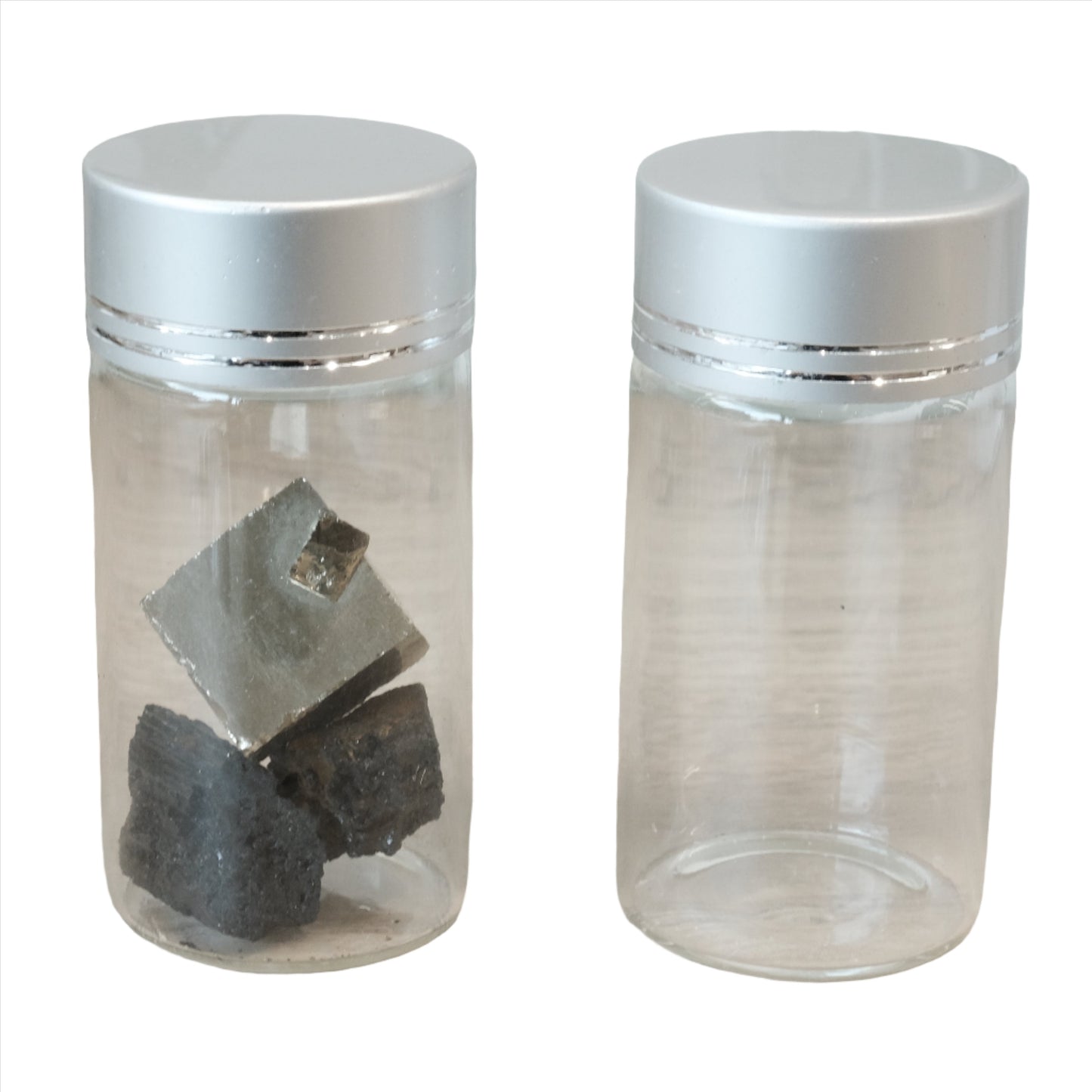 Two empty glass tubes with silver lids, one filled with metallic fragments, suitable for storing essence or other small items.