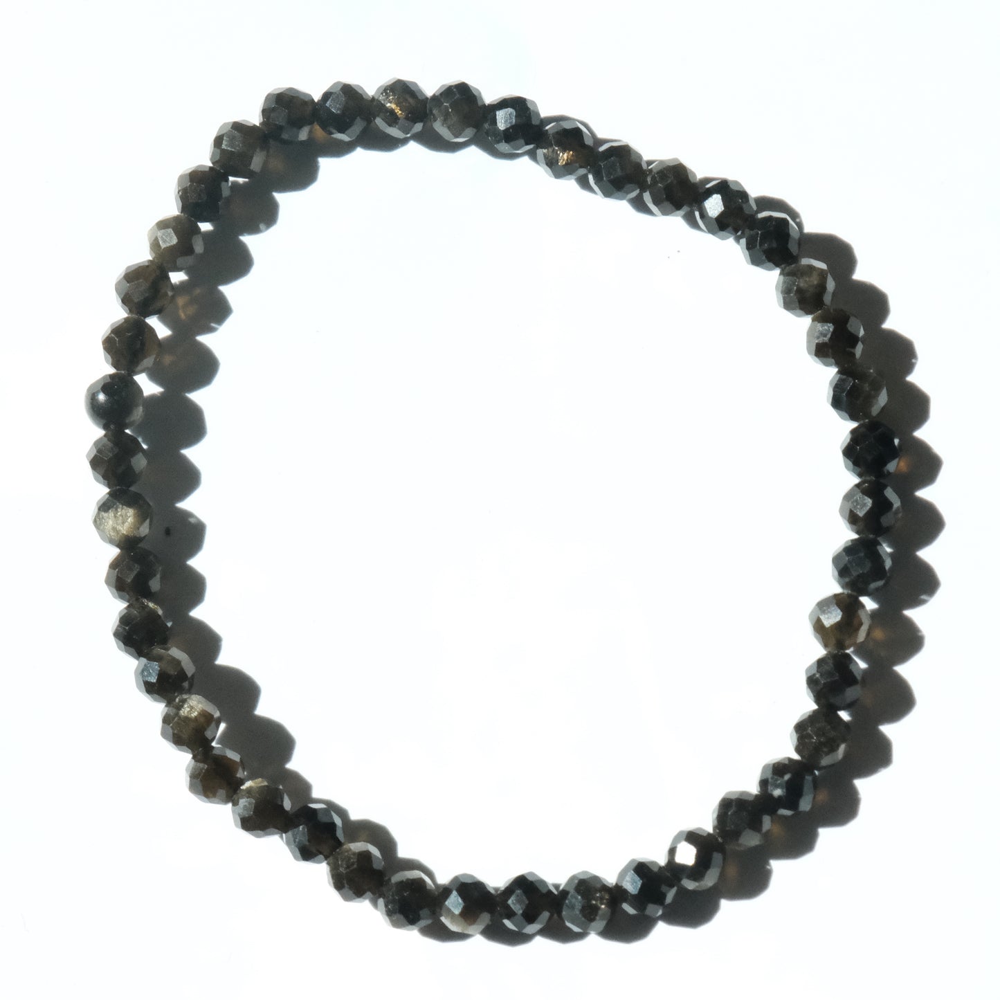 A beaded stretch bracelet made of faceted dark gray to black beads, arranged in a circle on a plain white background.