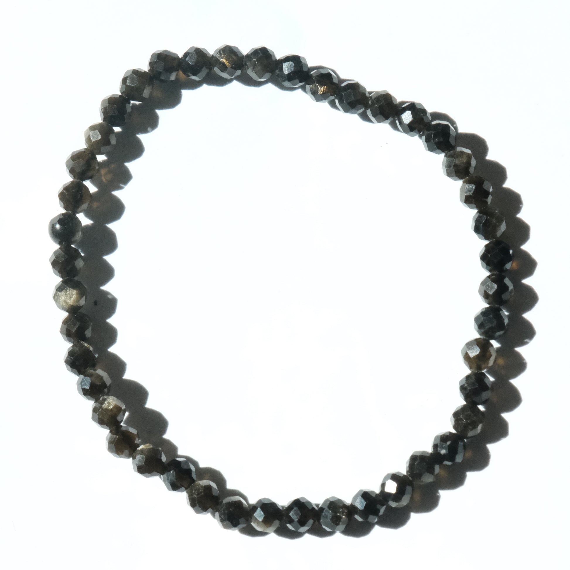A beaded stretch bracelet made of faceted dark gray to black beads, arranged in a circle on a plain white background.