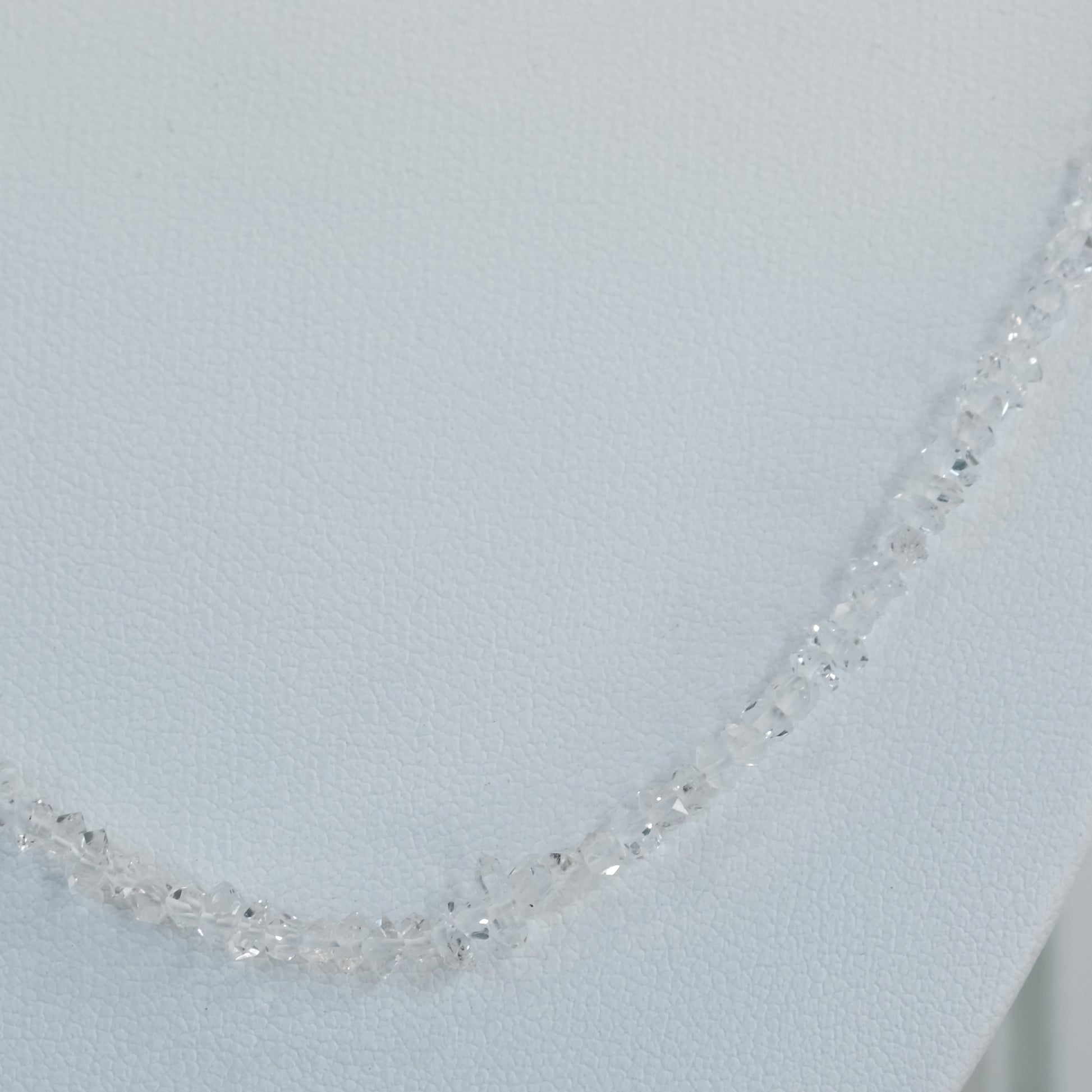 Elegant Herkimer Diamond bead necklace on display against a neutral background.